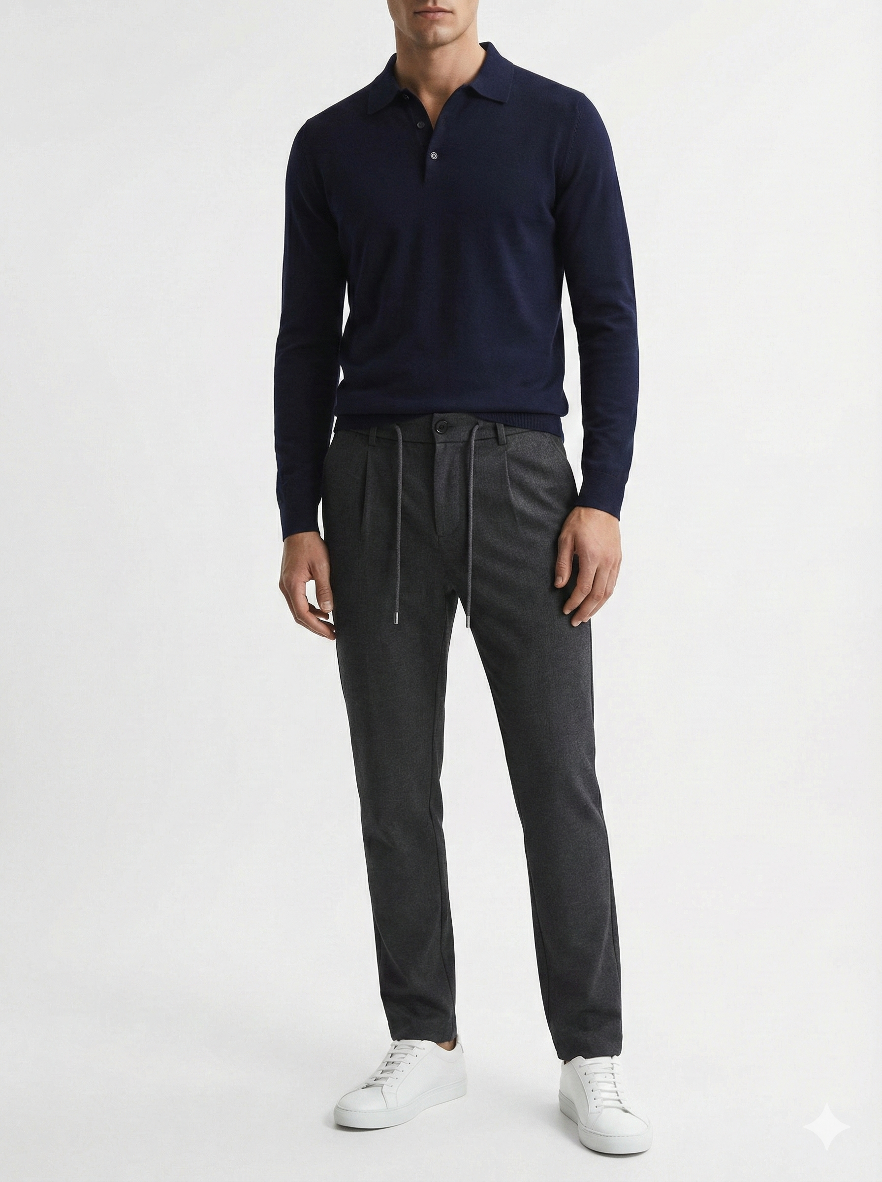Person wearing a navy sweater and gray pants on a white background